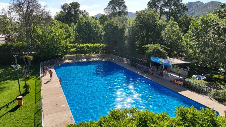 La piscina Acuasol vista desde el borde, entre el arbolado del parque