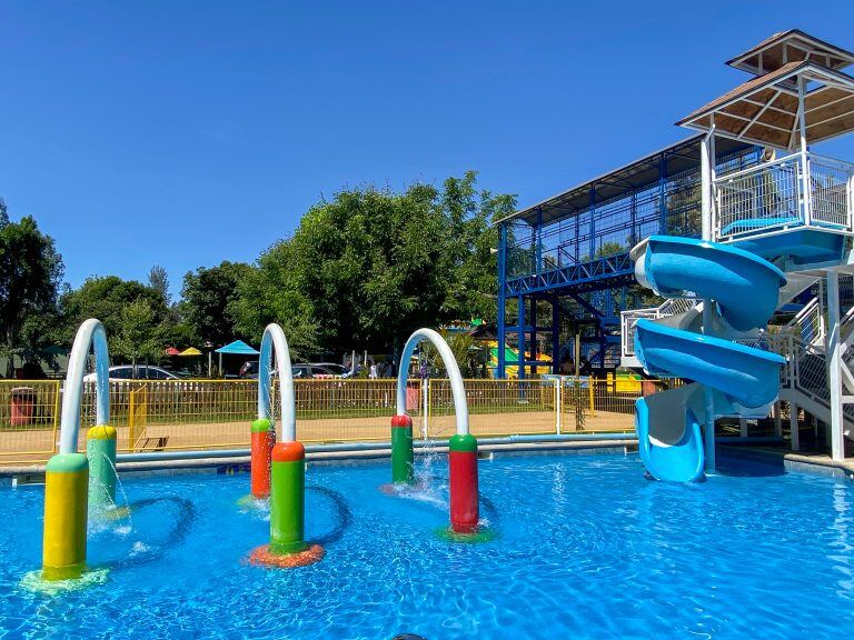 Los arcos de agua de la piscina Acuaspray, con la torre de toboganes detrás